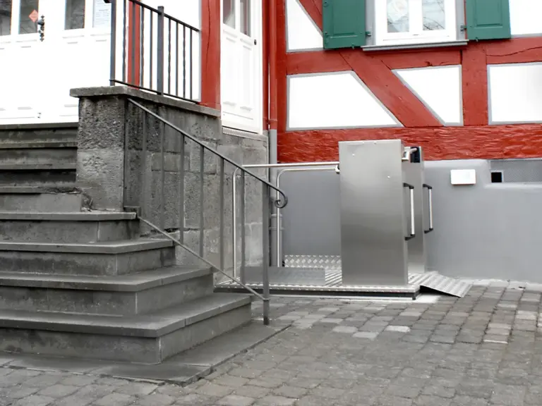 Wheelchair lift installed outdoors with access to elevated entry