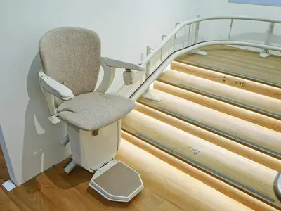 Beige stairlift seat on illuminated staircase in Deming.